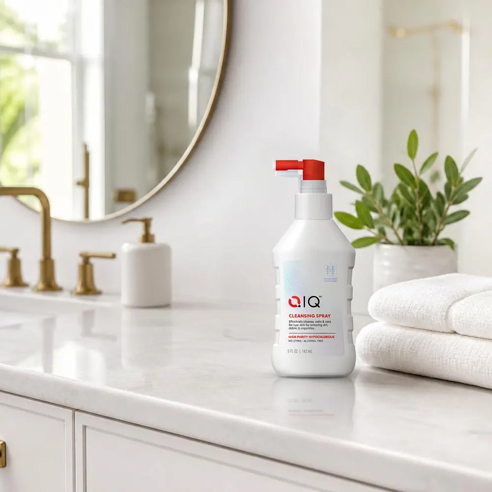 QIQ Skin Savior Cleansing Spray on a bright bathroom counter beside folded towels